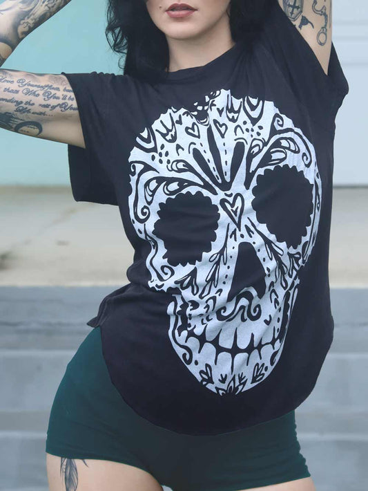 Woman wearing a black t-shirt with a white calavera skull design.