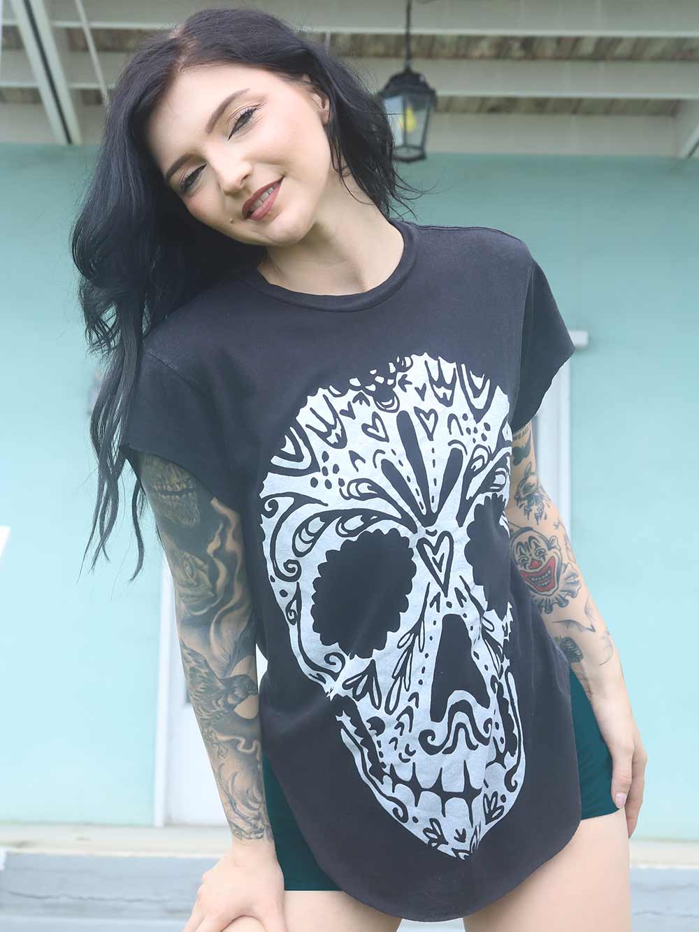 Person wearing a black t-shirt with a white skull design.