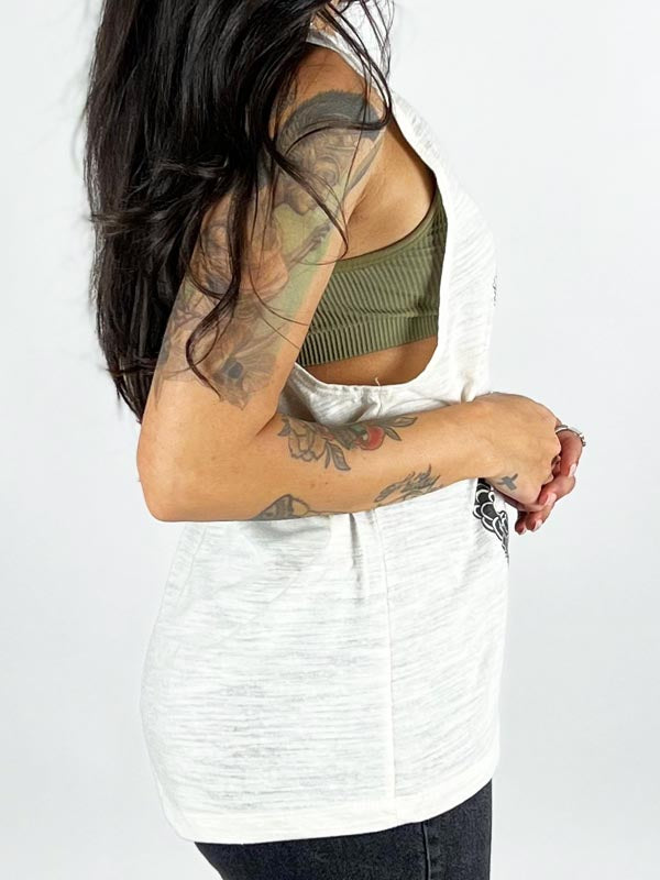 side of model in white tank top