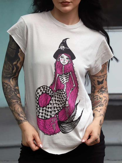 Person wearing a white t-shirt with a colorful mermaid design.