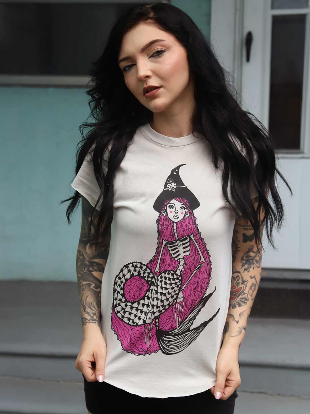Woman wearing a t-shirt with a mermaid witch skeleton design