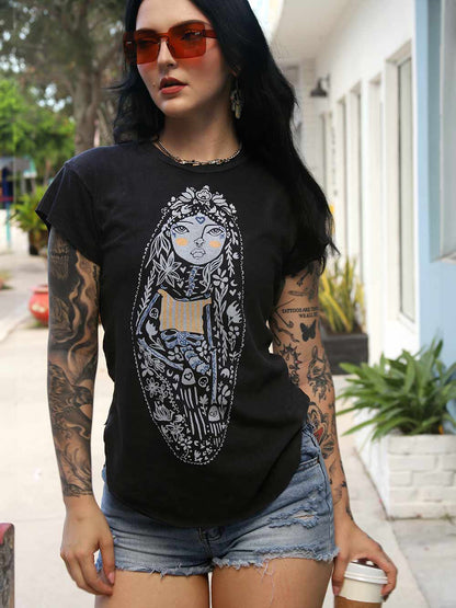 Person wearing a black t-shirt with a graphic design, standing outdoors.