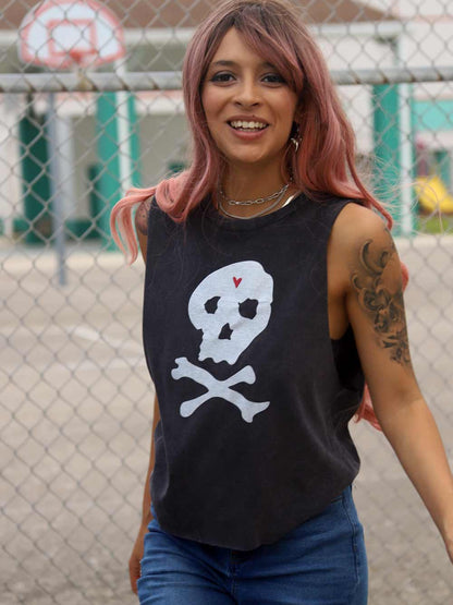 Woman wearing a black sleeveless shirt with a skull design near basketball court.