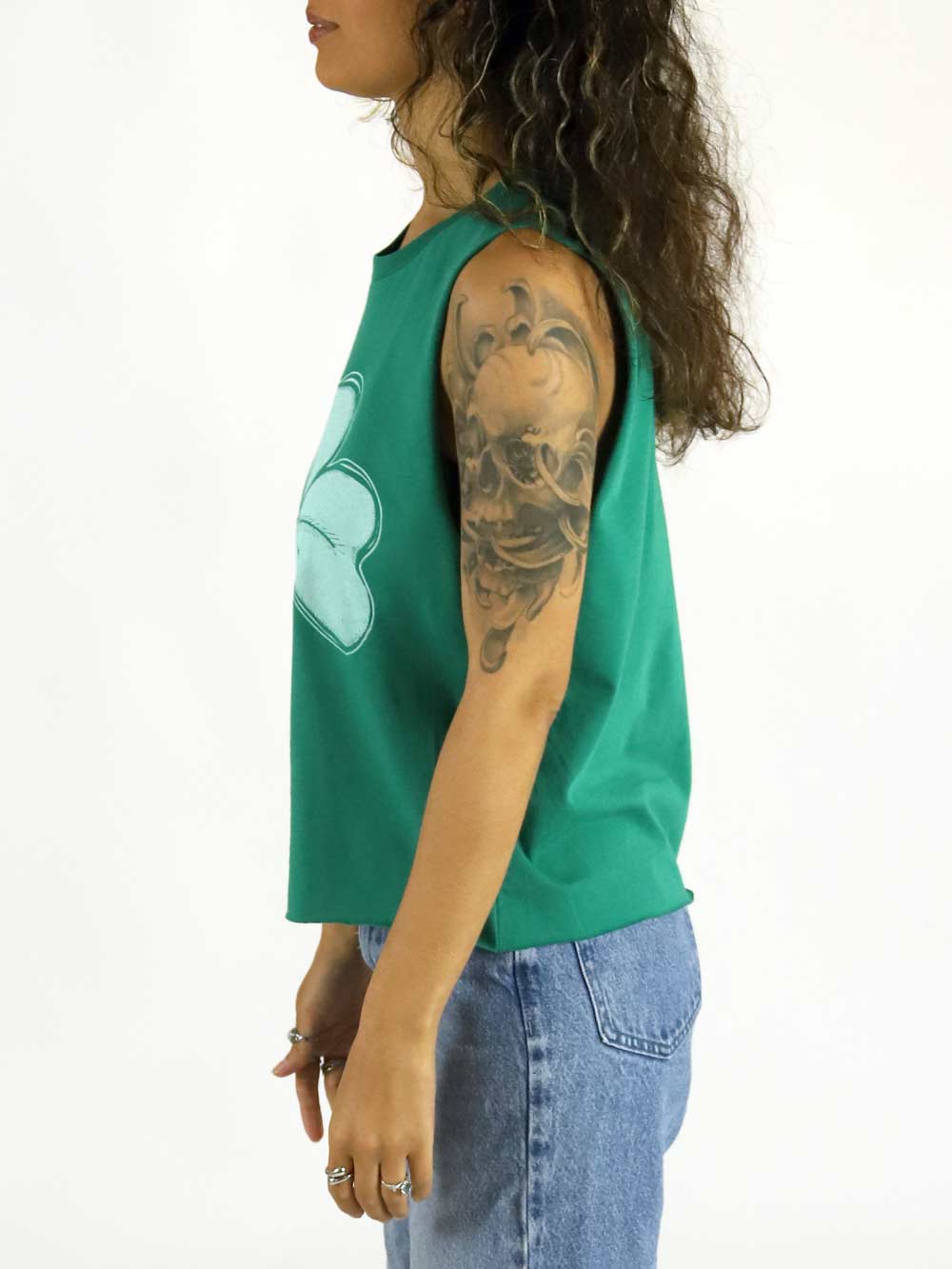 Woman wearing a green sleeveless top with a shamrock logo on a white background