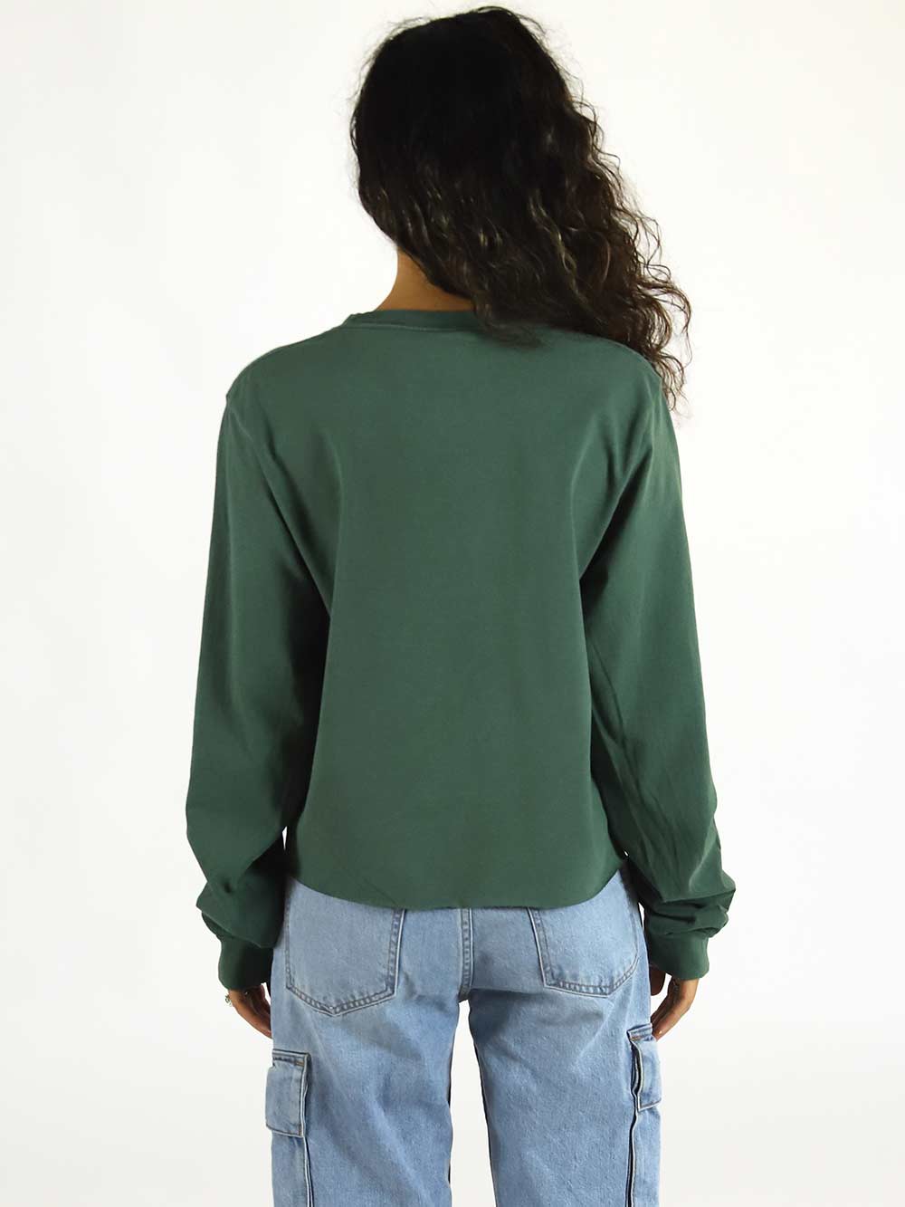 Person wearing a green long-sleeve shirt and blue jeans on a white background