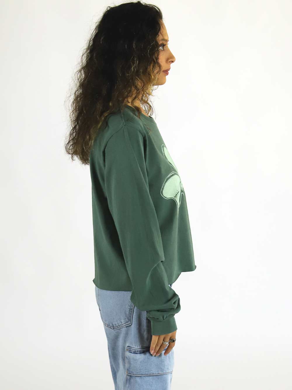 Person wearing a green long sleeve crop facing profile