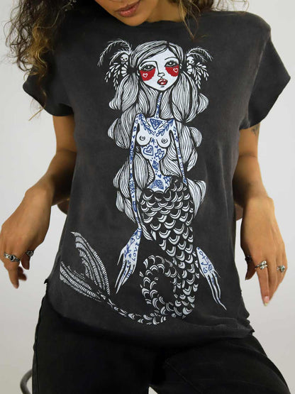 Female wearing a black t-shirt with a mermaid graphic design.