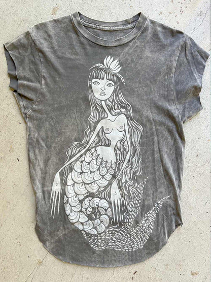 Gray t-shirt with a mermaid design on a concrete surface