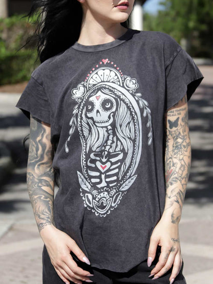 Woman wearing a dark gray t-shirt with a skeleton design outdoors.