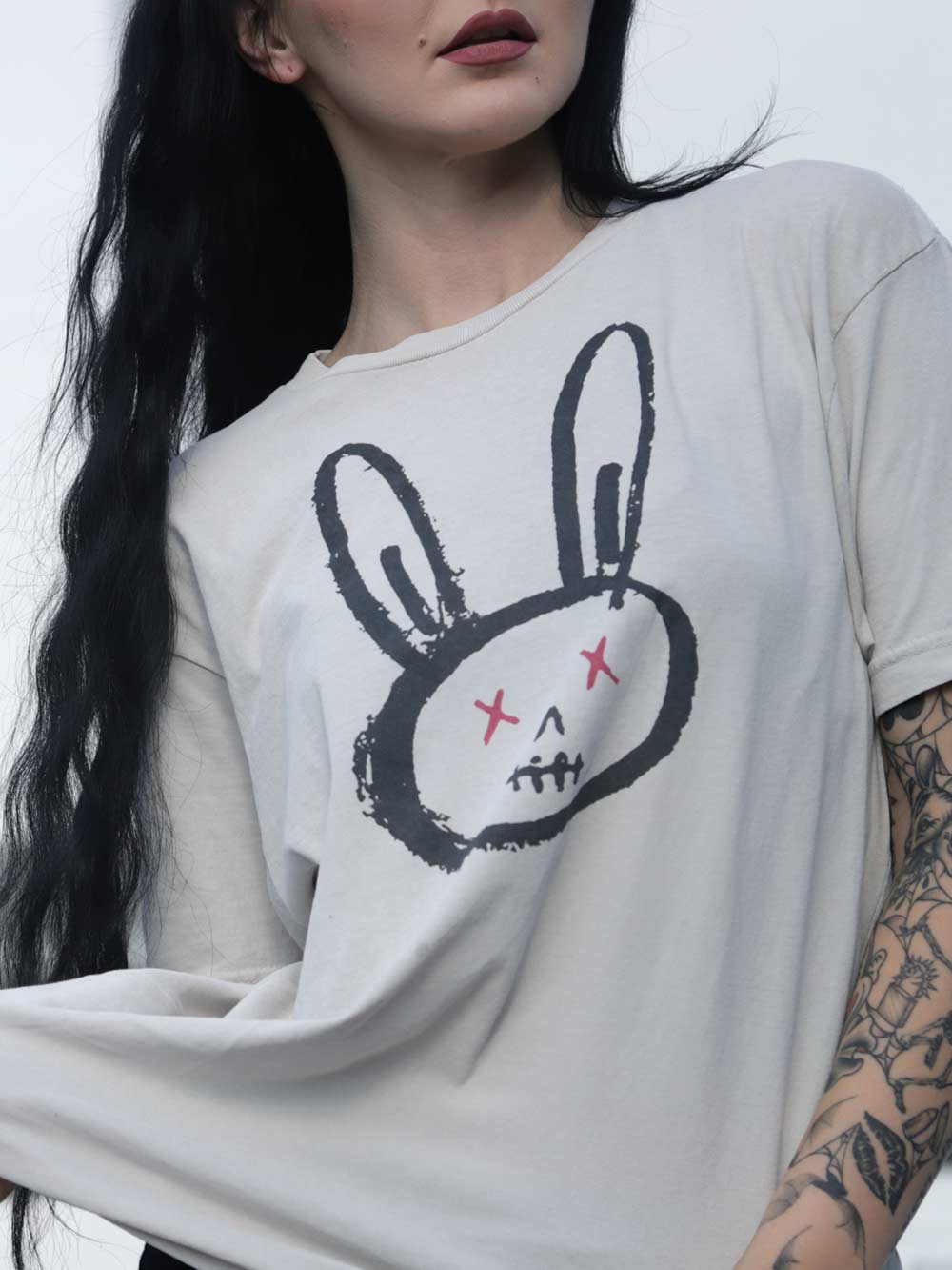 Model wearing a white t-shirt with a dead bunny rabbit graphic design on a plain background