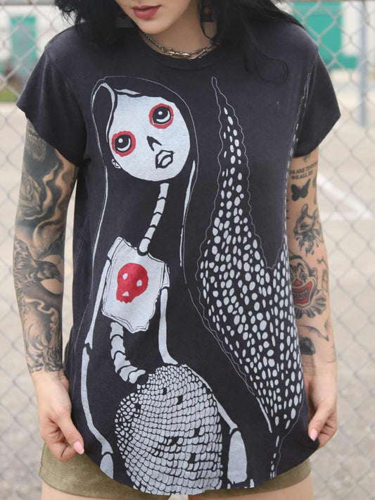 Woman wearing a black vintage  t-shirt with a graphic design of a skeleton mermaid.